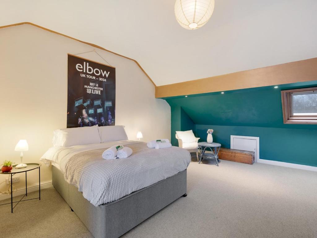 um quarto com uma cama e uma parede azul em Pass the Keys Spacious 5 Bed House Sleeps up to 12 em Manchester