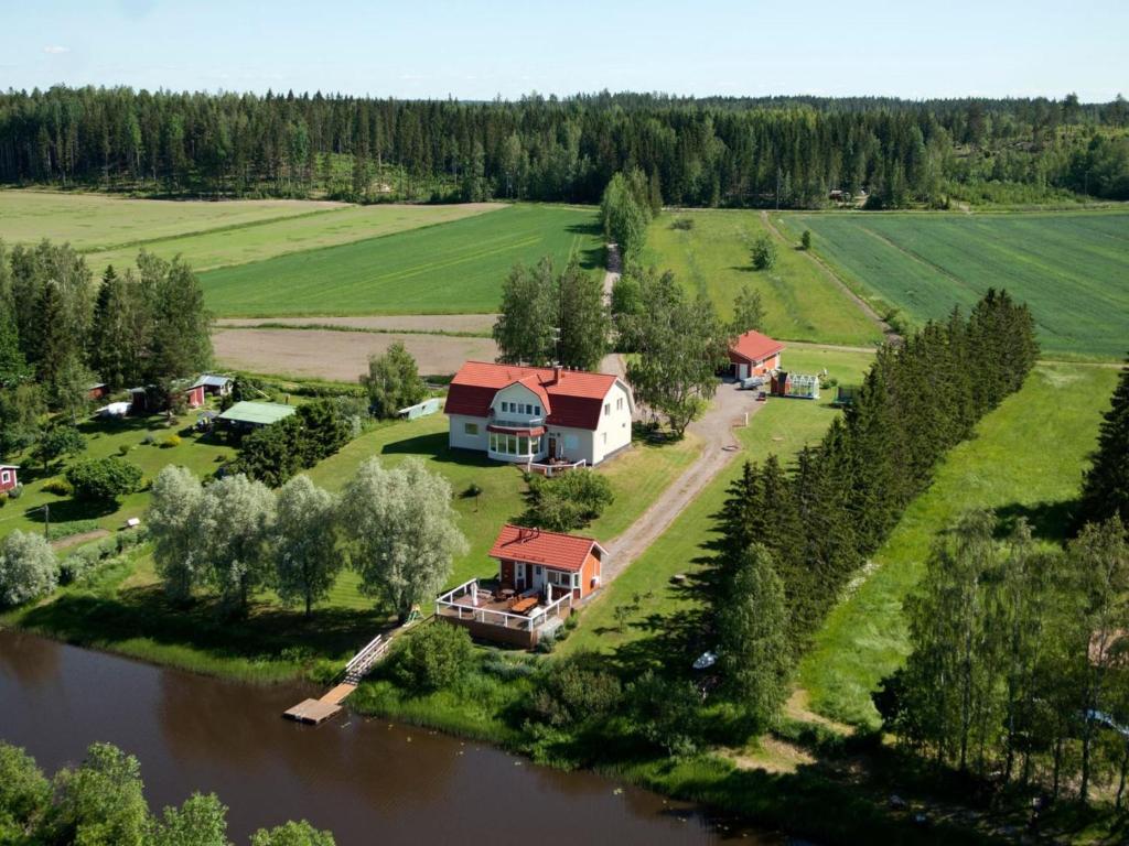 Holiday Home Mustijoenranta by Interhome في Nummistenkylä: اطلالة جوية على بيت في جزيرة في نهر