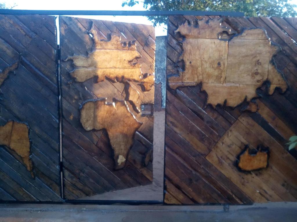 une clôture en bois avec une carte du monde dans l'établissement POVI Holiday Home, à Kasane