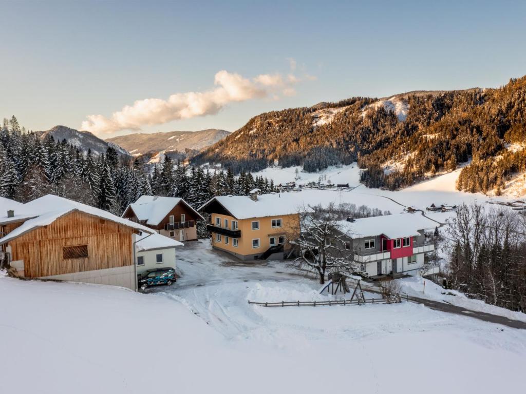 un pueblo cubierto de nieve con montañas en el fondo en Holiday Home Pilz by Interhome, en Rohrmoos-Untertal