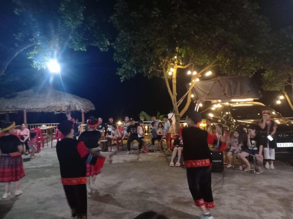 a group of people watching a performance at night at Dao homestay Vũ Linh in Yên Bình