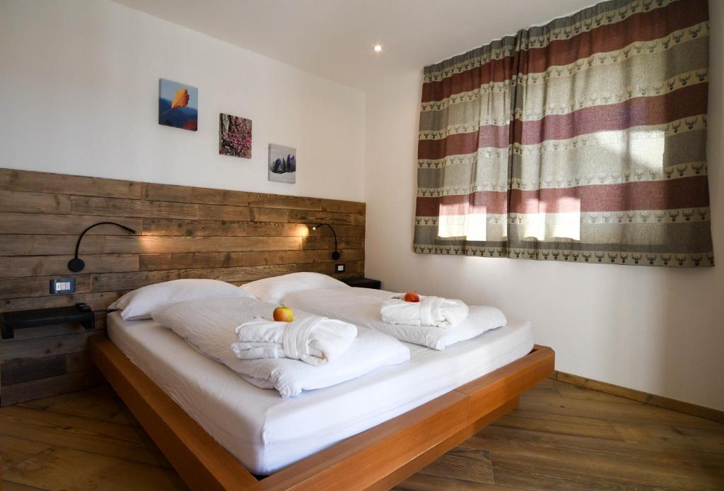 um quarto com duas toalhas brancas numa cama em Abete rosso em Tesero