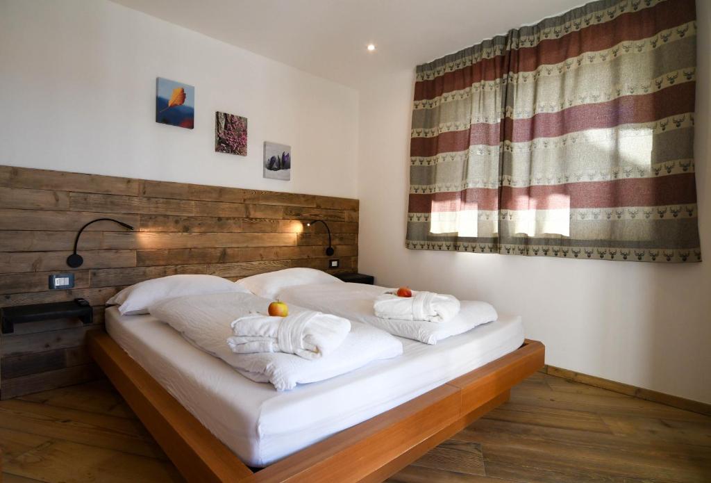 a bedroom with two white towels on a bed at Abete rosso in Tesero