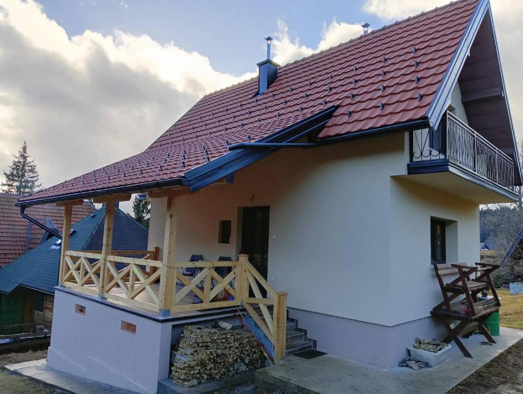 a house with a red roof and a balcony at Vikendica Vera in Mitrovac