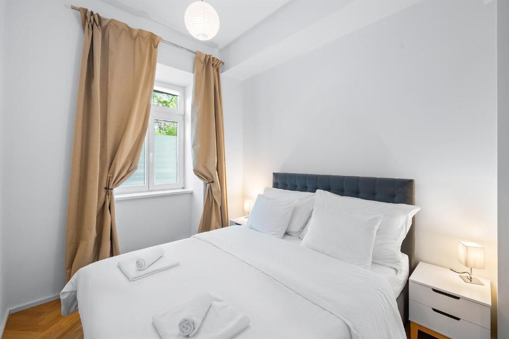 een slaapkamer met een wit bed en een raam bij Vienna Chic Residences #Cozy Suite in Wenen