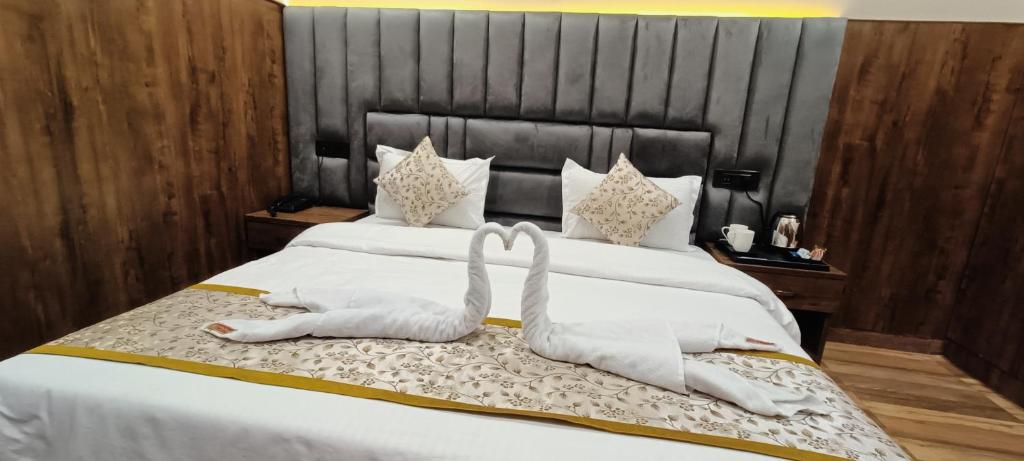 a bed with two swans made out of towels at Hotel Madhavam- 250 Mtr from Mathura Railway Station in Mathura