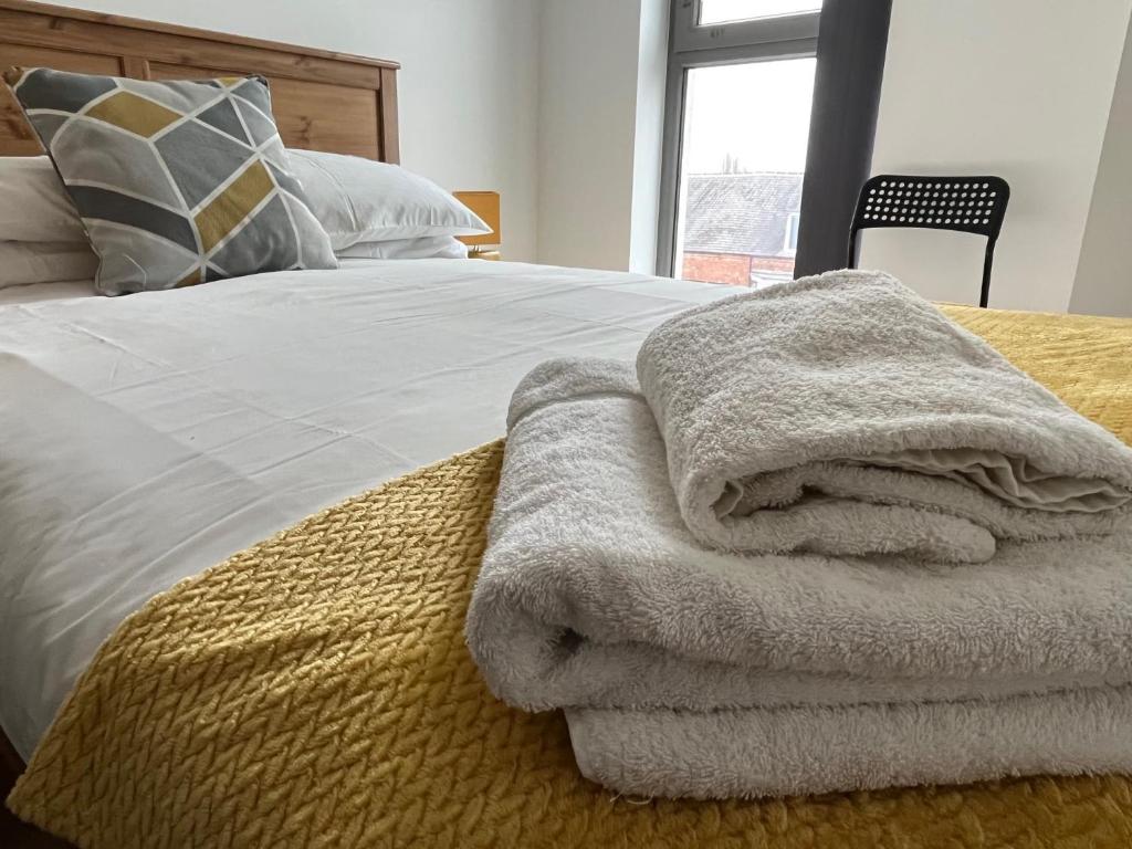 a pile of towels sitting on top of a bed at Central Darlington Apartment With Parking in Darlington