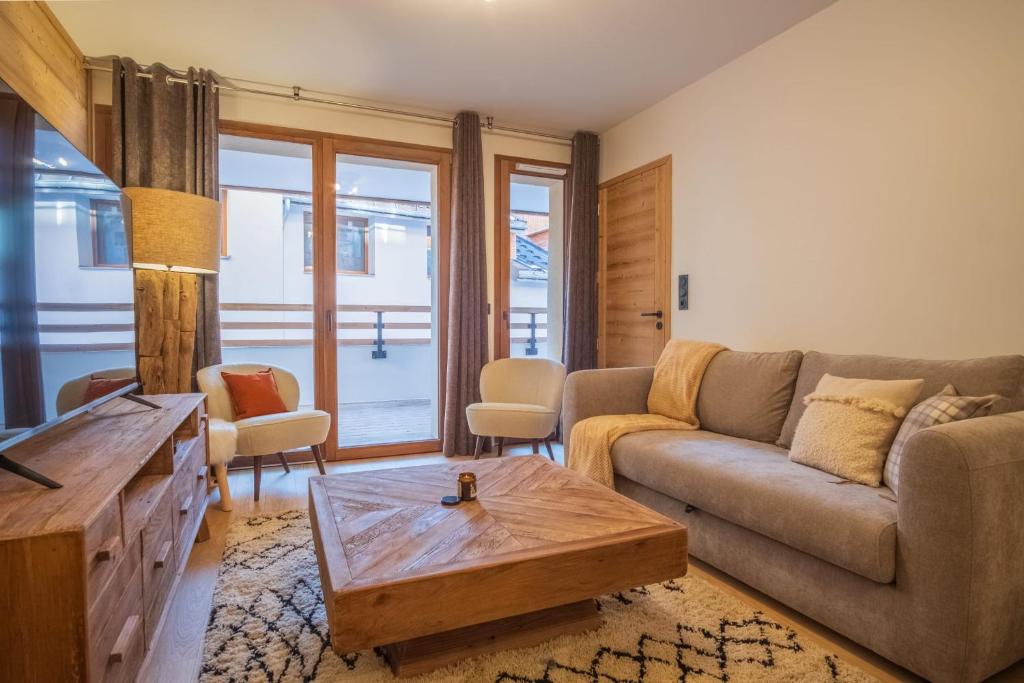 a living room with a couch and a coffee table at Charming three-room apartment in Huez - Welkeys in LʼHuez