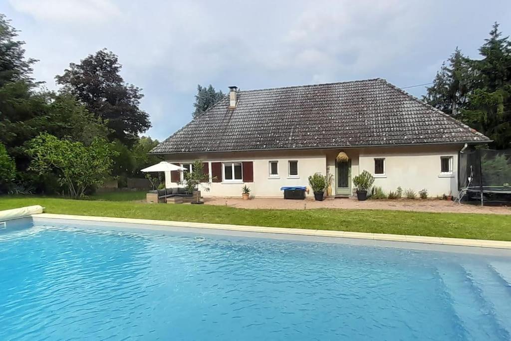 une maison avec une piscine en face de celle-ci dans l'établissement Villa au calme avec grande piscine, à Villerest