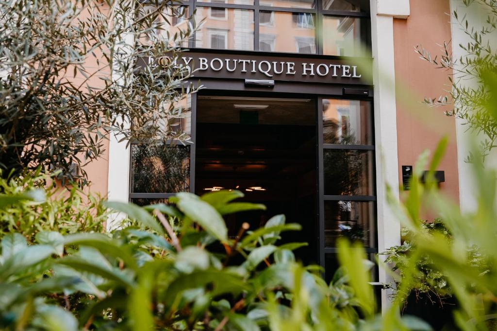 una puerta a un hotel boutique con plantas en primer plano en Loly Boutique Hotel Roma, en Roma