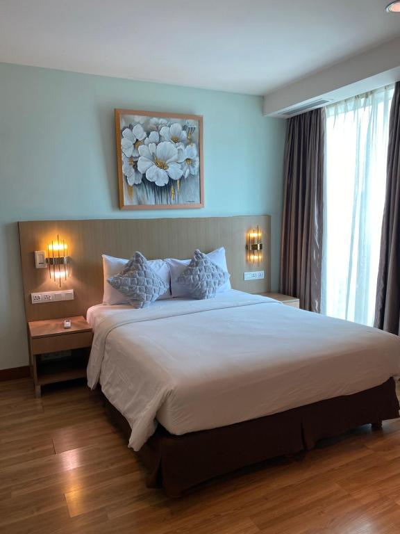 a bedroom with a large white bed with two lamps at The H Tower Residence by YLS Stay in Jakarta