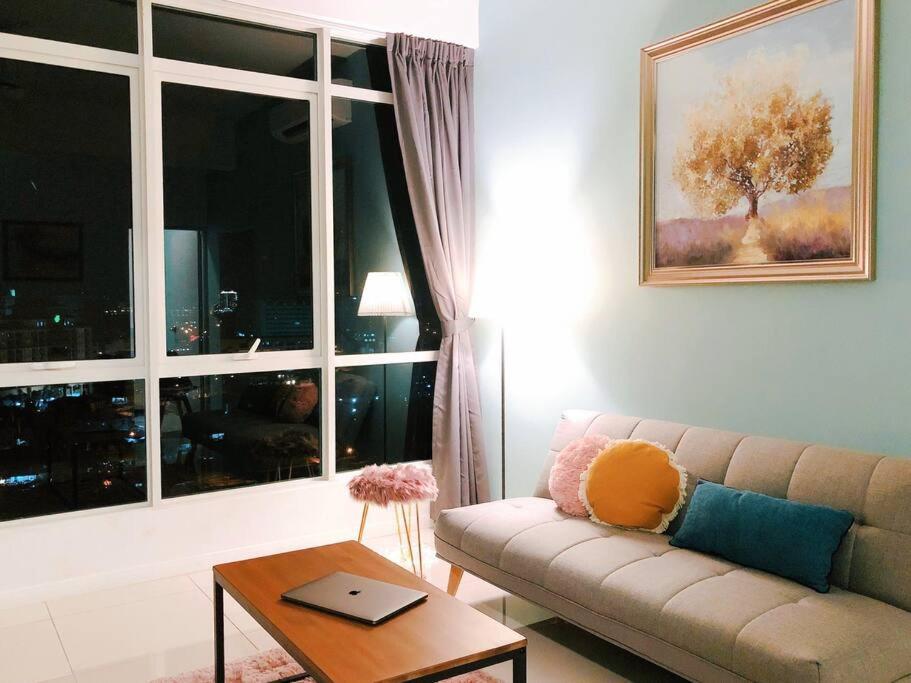 een woonkamer met een bank, een tafel en een raam bij Morning Tiffany / Opposite IMAGO / KK City Center in Kota Kinabalu