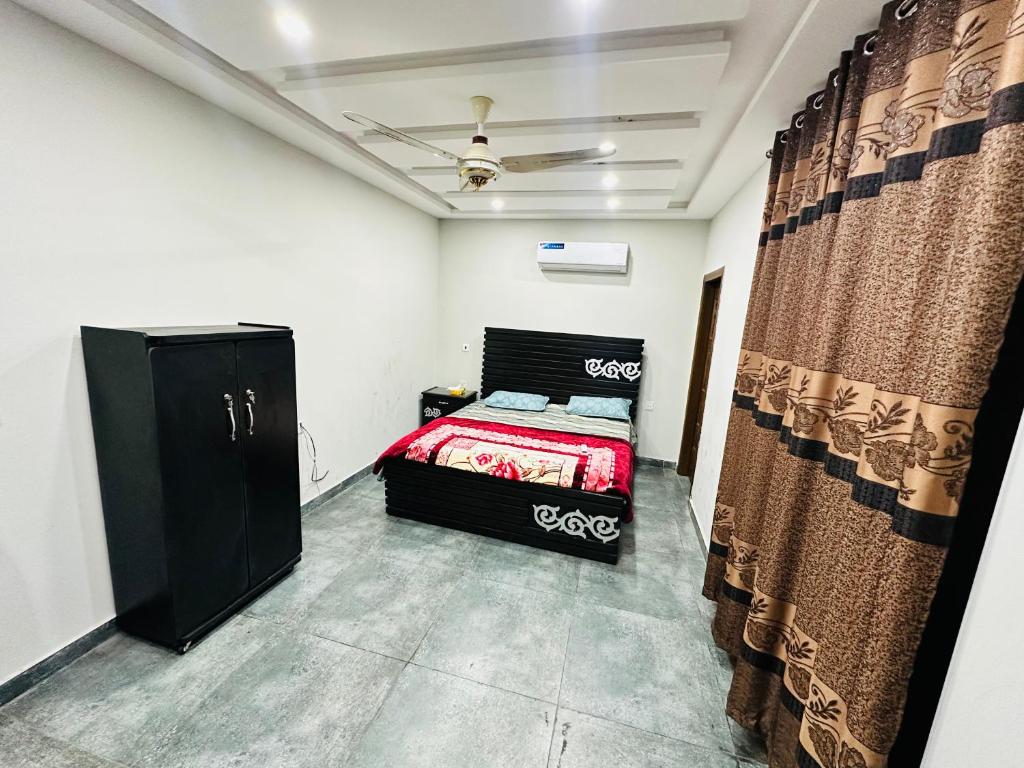 1 dormitorio con 1 cama en una habitación con cortinas en AS Plaza, en Gujrānwāla