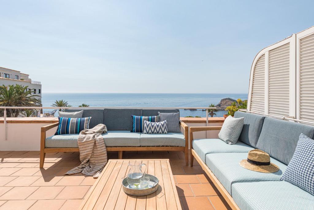 - une terrasse avec des canapés et une table donnant sur l'océan dans l'établissement Casa Sa Sal _ Costa Brava, à Begur