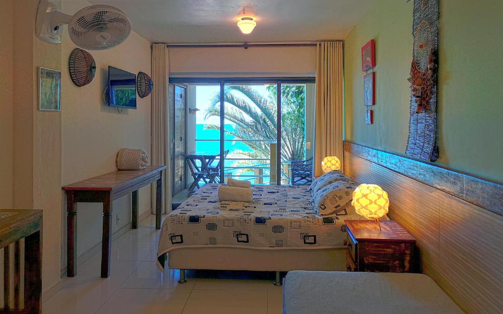 a bedroom with a bed and a view of the ocean at Pousada Bem Te Vi in Guarapari