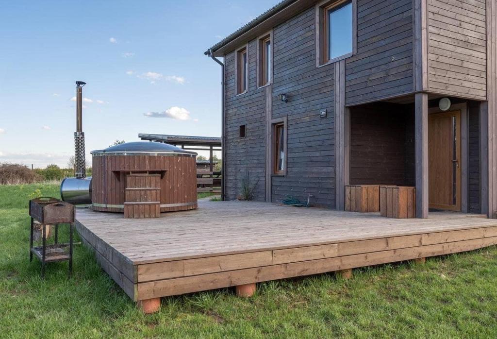 a large deck with a hot tub next to a house at Pirtis link Moletu in Vilnius