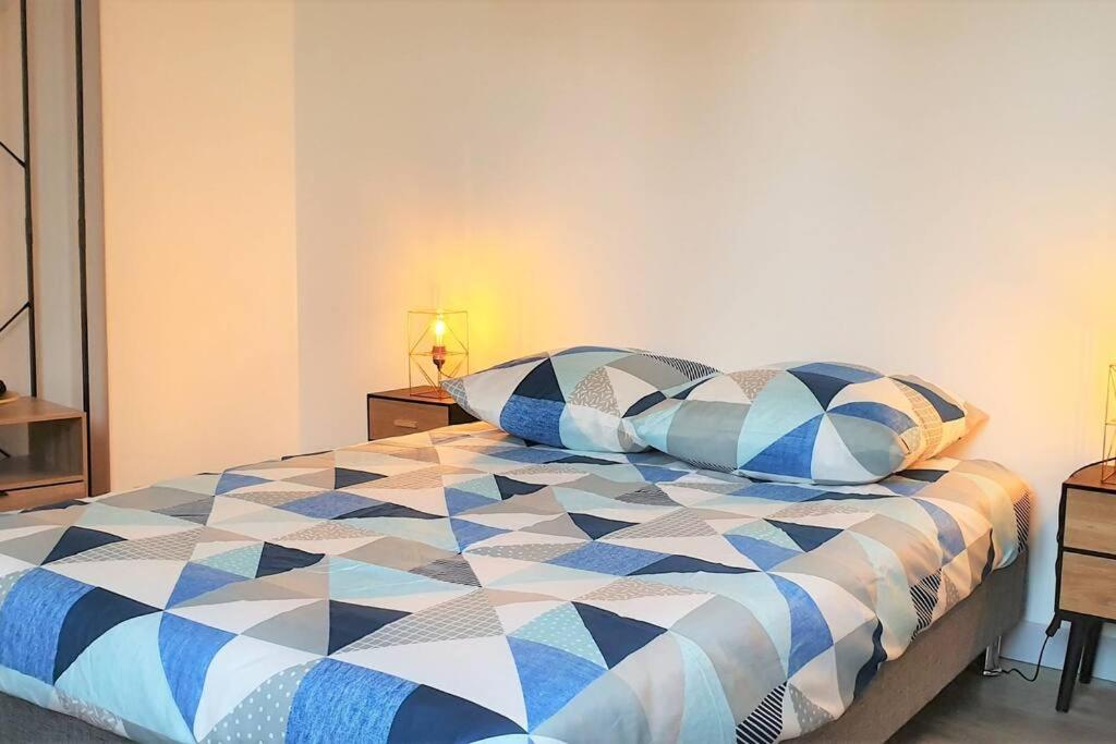 a bedroom with a blue and white bed with pillows at Cocon Rue Ecuyère - Calme- 2ch - 6pers in Caen