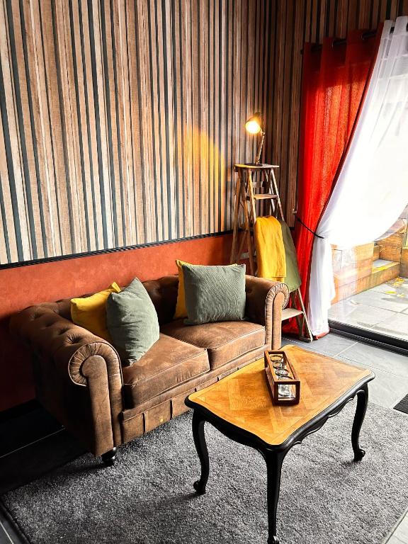 un salon avec un canapé et une table basse dans l'établissement La Grange Aux Hirondelles - Chambre Atelier, à Woignarue
