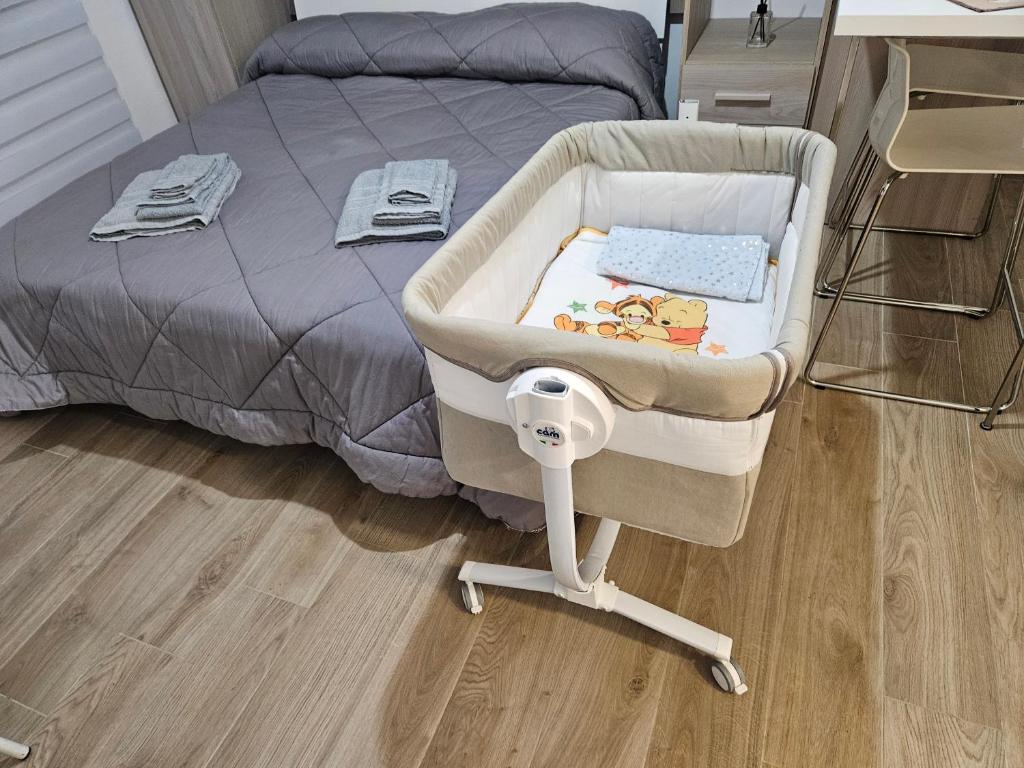 a baby crib sitting next to a bed at B&B DEI SOGNI in centro, con facilità di parcheggio in Cosenza