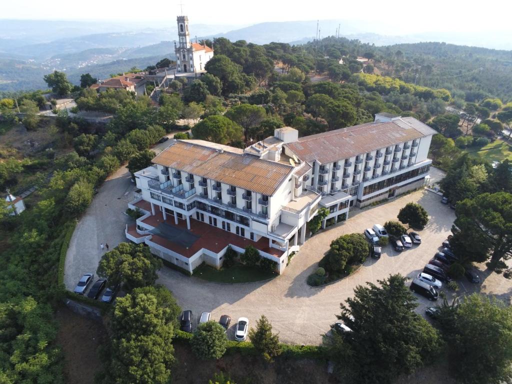uma vista superior de um grande edifcio com carros estacionados na frente em Hotel Senhora do Castelo em Mangualde