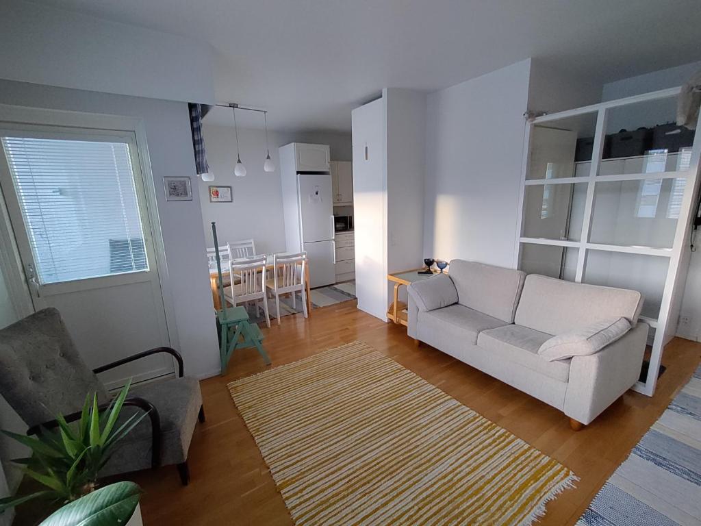 ein Wohnzimmer mit einem weißen Sofa und einer Küche in der Unterkunft Viihtyisä kaksio ydinkeskustassa in Lappeenranta