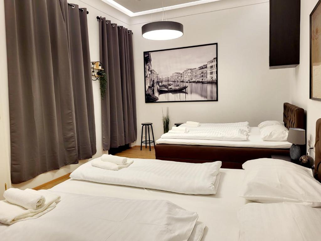 two beds in a room with white sheets at City Apartment Schotten Vienna in Vienna