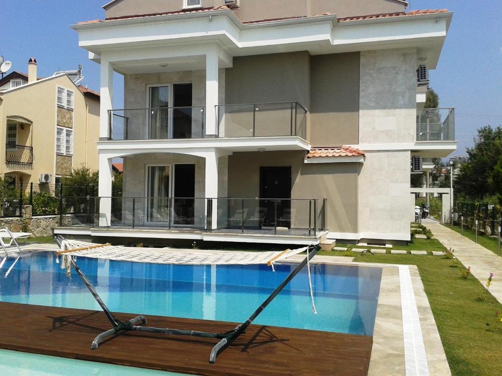 a house with a swimming pool in front of it at Lighthouse Nadia Aparts in Fethiye