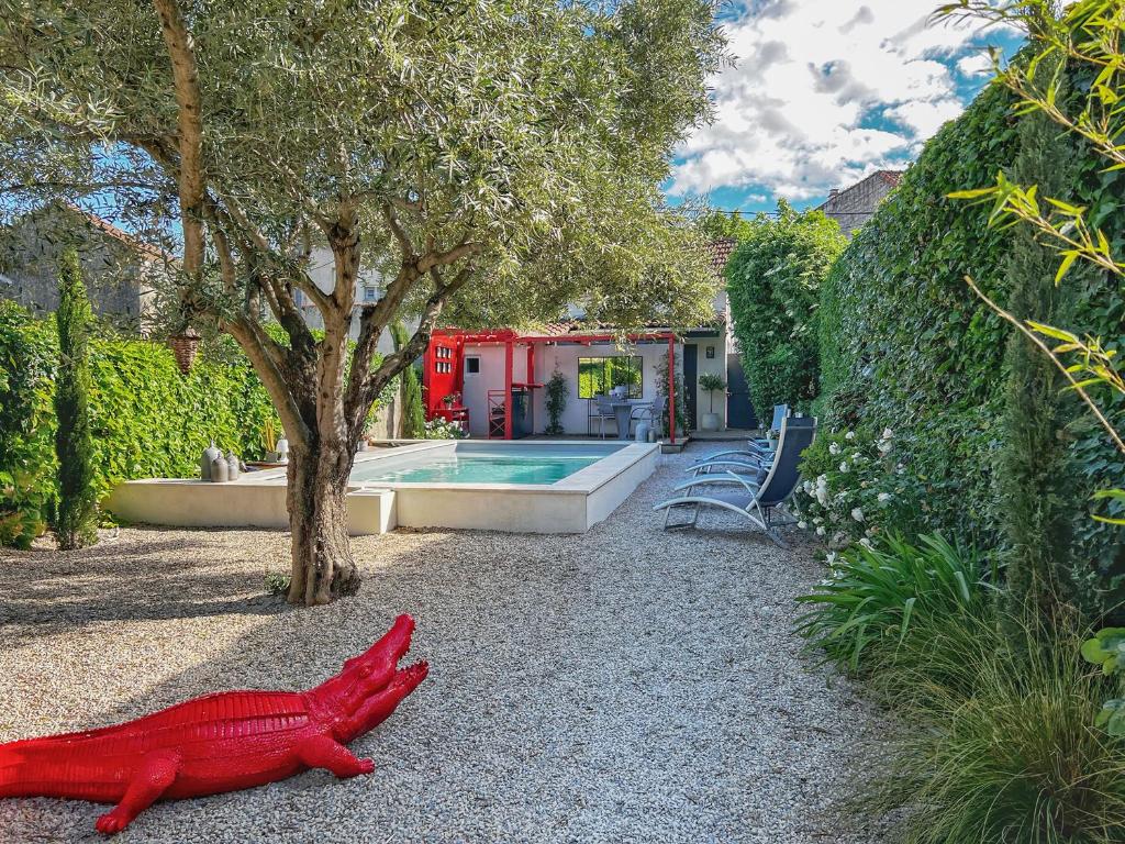 a red fish laying on the ground next to a house at L’annexe in Orange