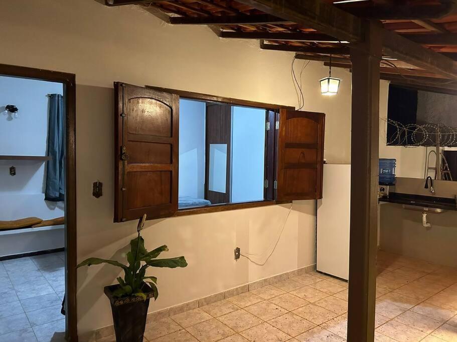 uma cozinha com uma janela e um vaso de plantas em Suíte c/ar e varanda perto do Parque de Exposições em Patos de Minas