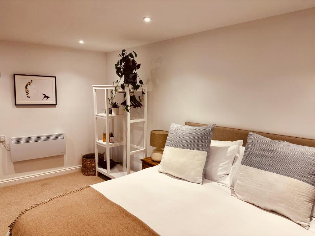 1 dormitorio con 1 cama con sábanas y almohadas blancas en The Ventnor Annex, en Ventnor