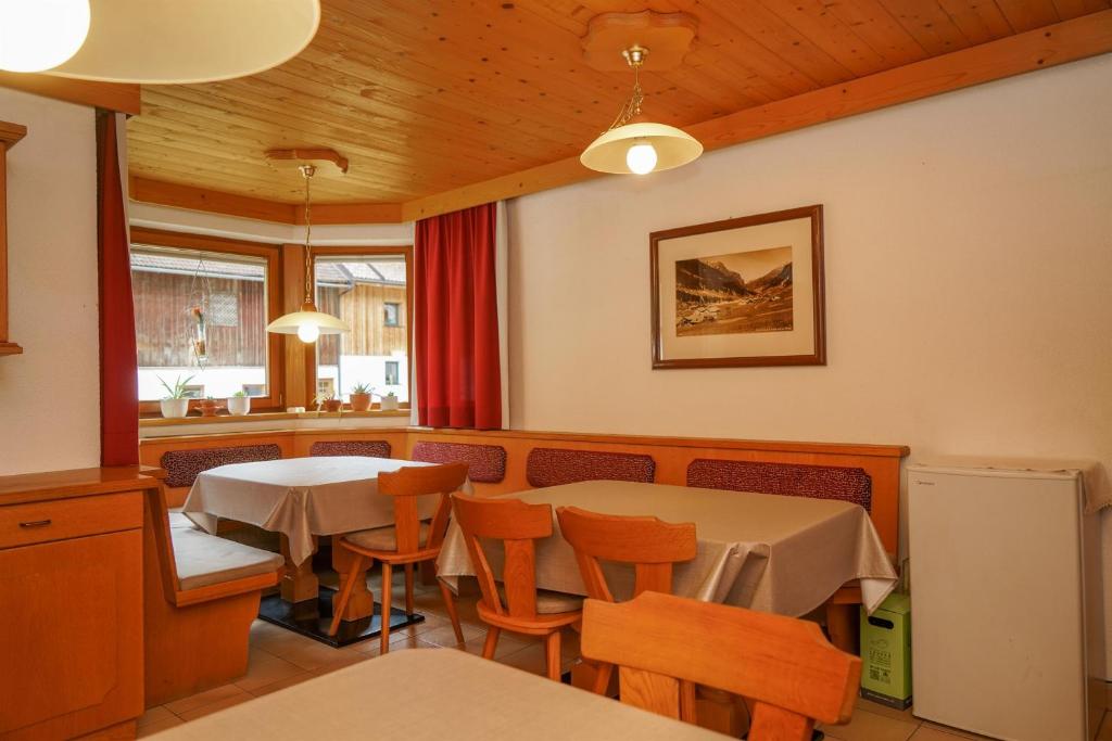 ein Restaurant mit zwei Tischen und Stühlen und einer Theke in der Unterkunft Birkenheim in Sankt Leonhard im Pitztal