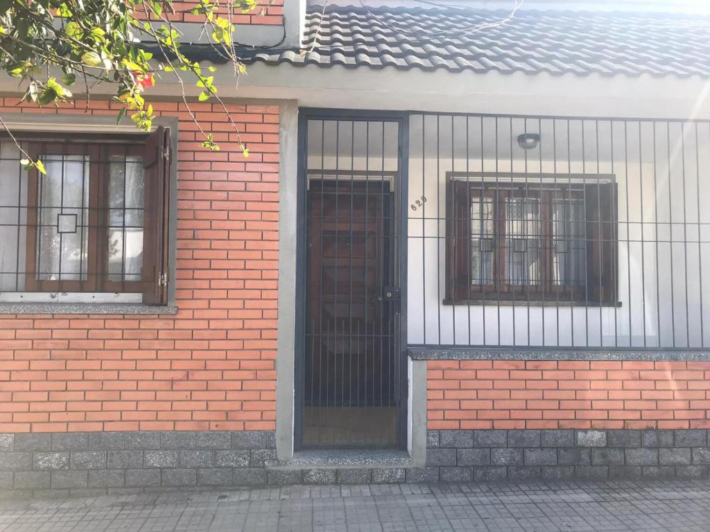 um edifício de tijolos com uma porta e duas janelas em La casa de la abuela em Rivera