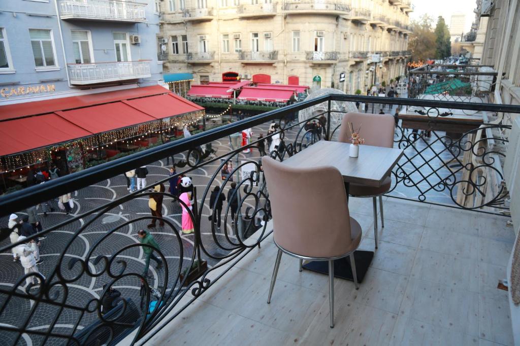 a balcony with two chairs and a table on a railing at Solo Hotel in Baku
