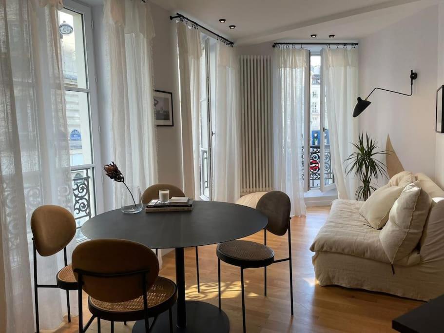 un salon avec une table et un canapé dans l'établissement Marais - Bright one-bedroom decorated with taste, à Paris