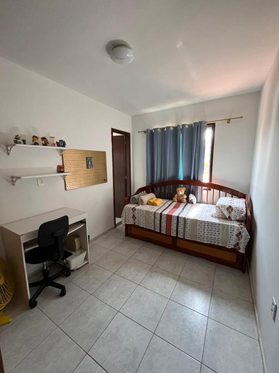 a bedroom with a bed and a desk and a chair at Casa em Praia Seca, Araruama. in Araruama