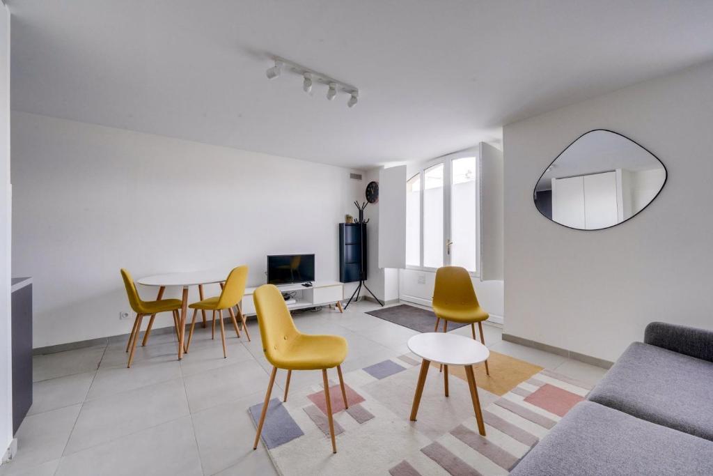 a living room with a table and yellow chairs at Very lovely apartment Bordeaux in Bordeaux