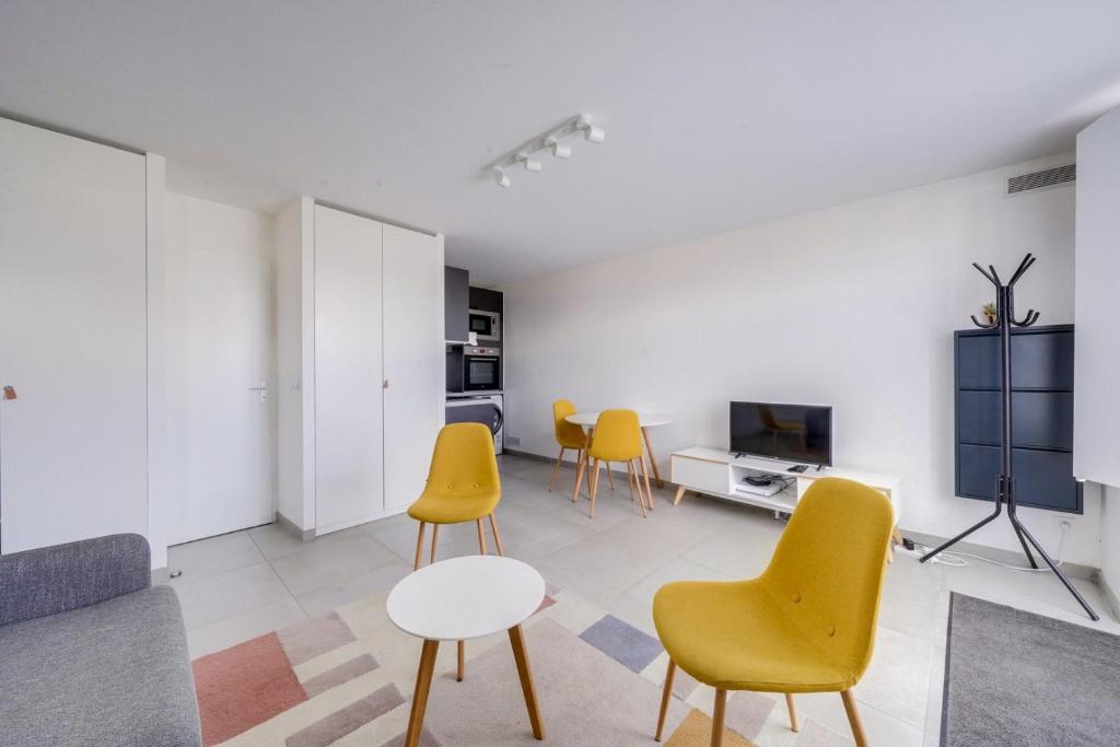 a living room with yellow chairs and a table at Very lovely apartment Bordeaux in Bordeaux