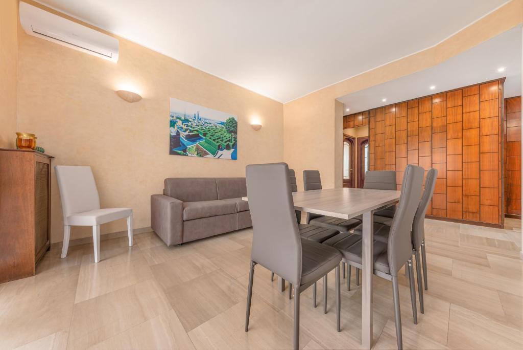 ein Esszimmer mit einem Tisch und einem Sofa in der Unterkunft Casa da Suite Superba in Mailand