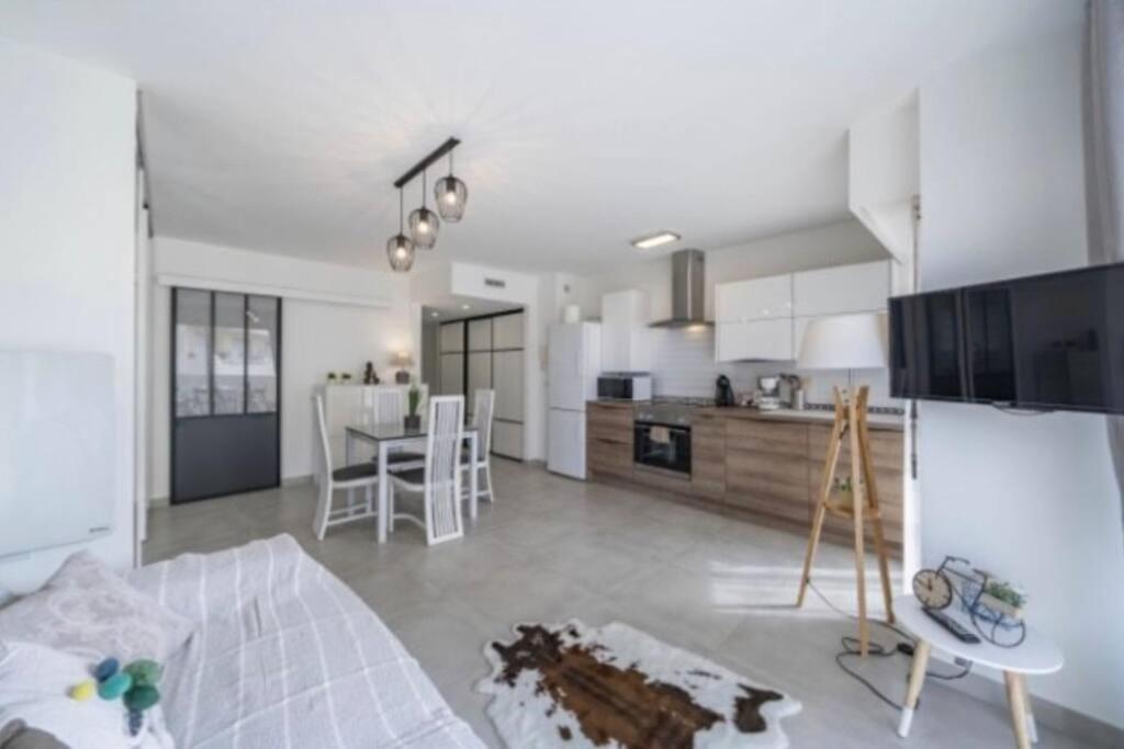 un salon et une cuisine avec un canapé et une table dans l'établissement Magnifique studio au pied des plages, à Cannes