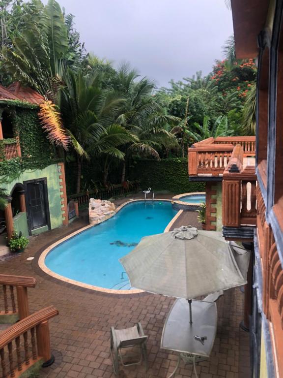 piscina con ombrellone e tavolo di Hidden oasis a Mandeville