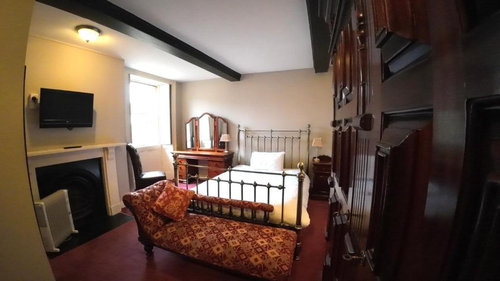 a living room with a couch and a fireplace at The Old Manor House Hotel in Keynsham