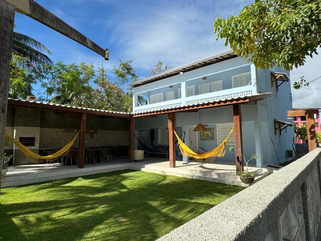 una casa con hamacas amarillas en el patio en Casa Maragogi, Ponta de Mangue - AL, en Maragogi