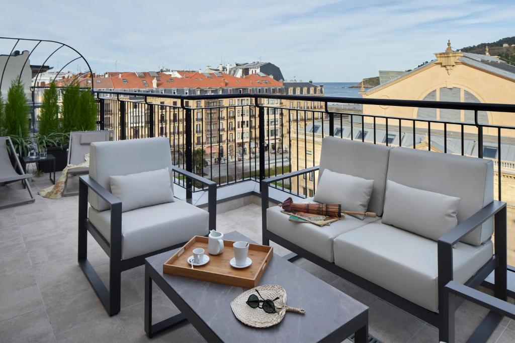 a balcony with two chairs and a coffee table at Eki Terrace by FeelFree Rentals in Donostia-San Sebastián
