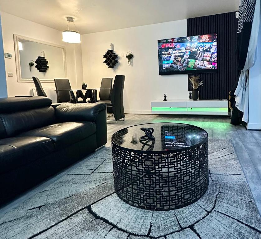 uma sala de estar com um sofá e uma mesa de centro em Private Modern Ensuite Room near Etihad Stadium em Manchester