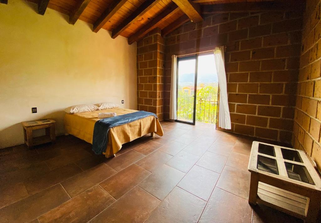 a bedroom with a bed and a large window at Casa Las Animas Malinalco in Malinalco