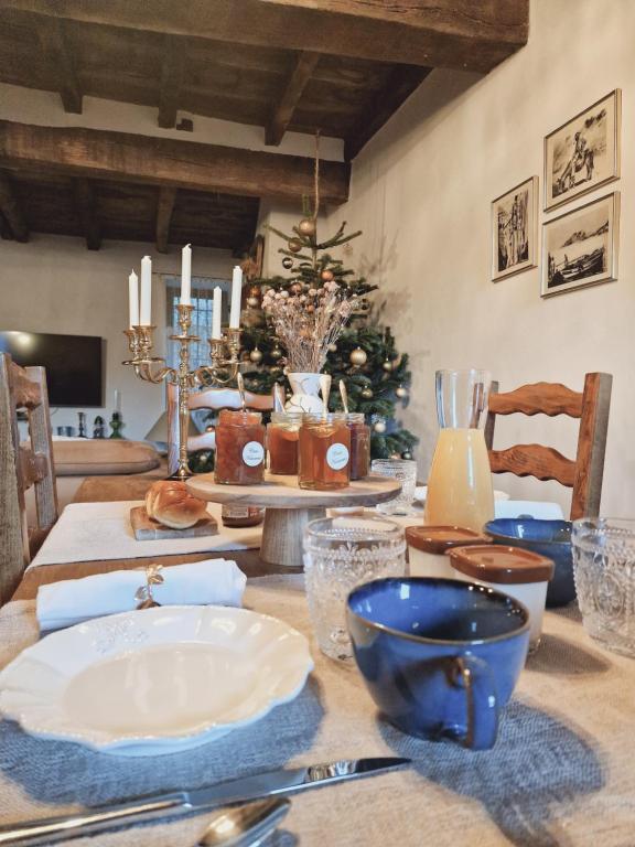 una mesa de comedor con un árbol de Navidad en el fondo en Casa Nanuccia, en Bastelica