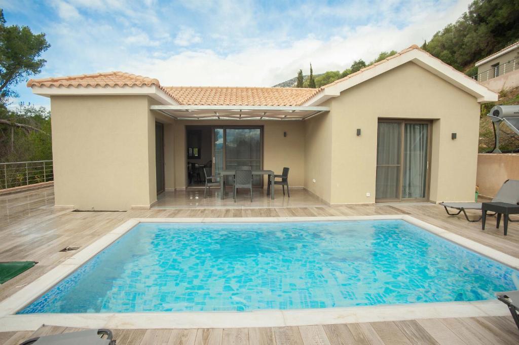 a swimming pool in a villa with a house at Villa Gerasmia in Trapezaki