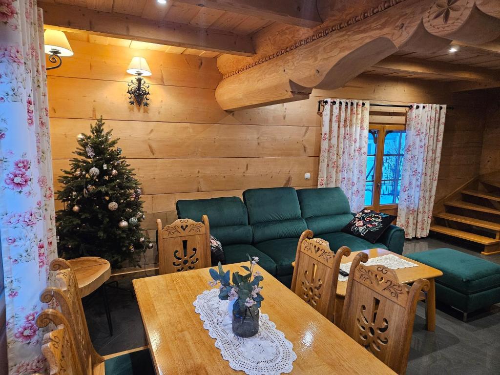 a living room with a christmas tree and a table at Domek Góralski Amelka in Poronin