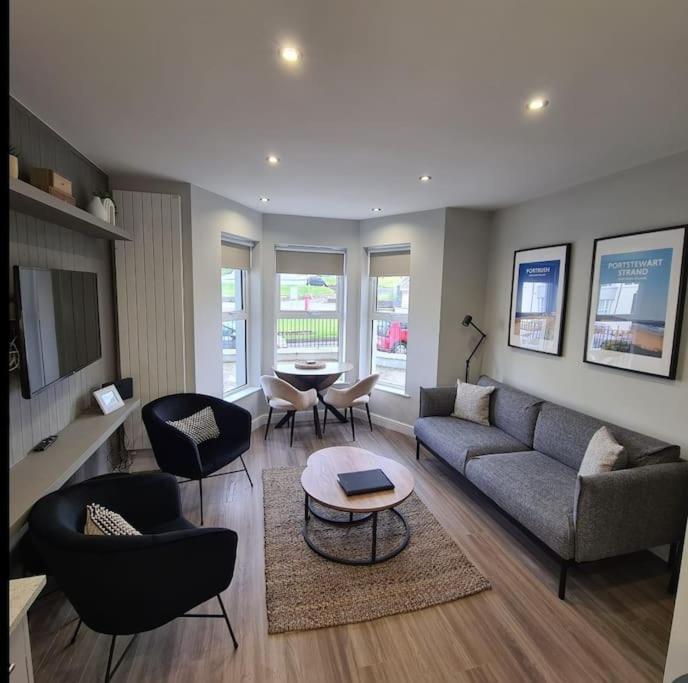 a living room with a couch and chairs and a table at The Cove Apartment, Portstewart near Prom, Parking in Portstewart