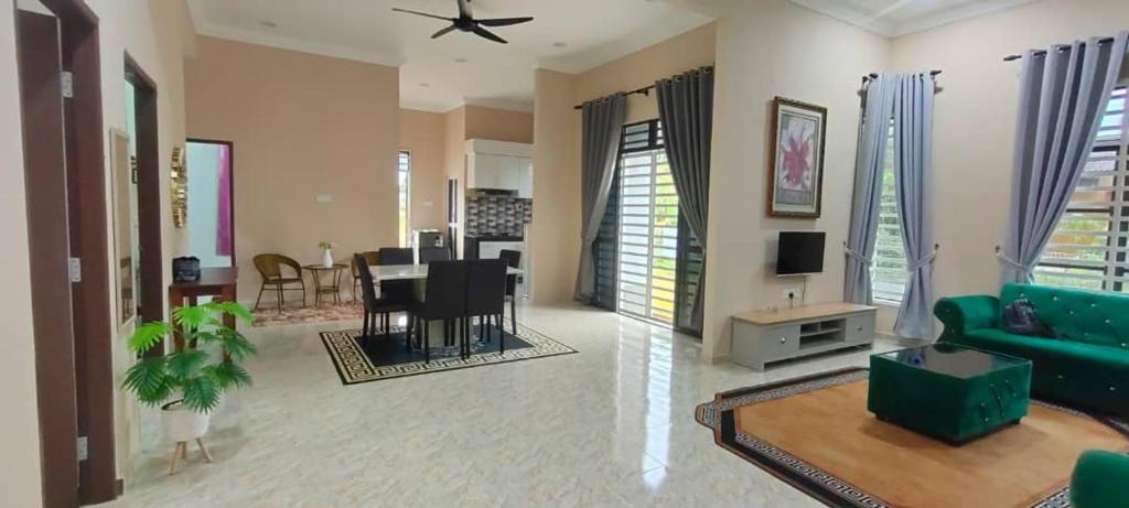 a living room with a green couch and a table at Homestay Kaklong in Kuala Terengganu